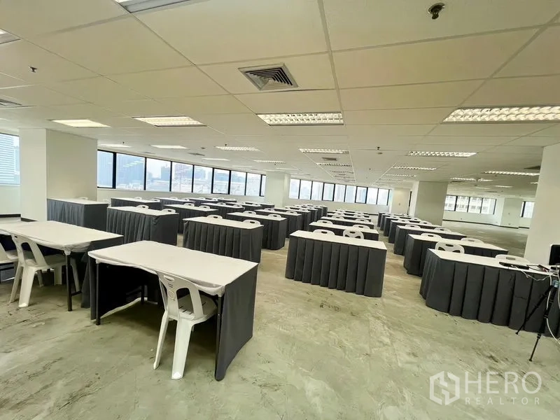 สำนักงาน ให้เช่า - พื้นที่สำนักงานสว่าง จัดวางโต๊ะอบรมและเก้าอี้หลายแถว ข้างหน้าต่างพาโนรามาวิวเมือง.