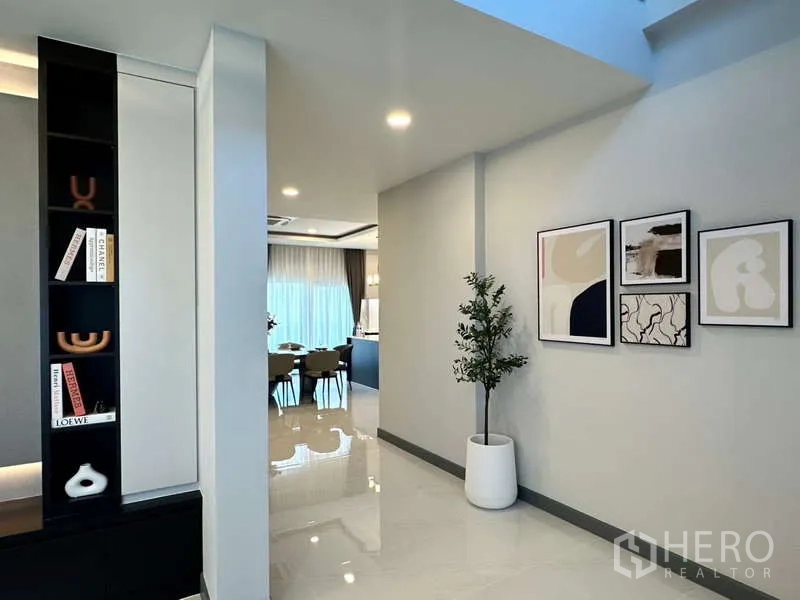 บ้าน ให้เช่าในBang Phli, Samut Prakan - โถงเดินสู่ห้องอาหาร พร้อมภาพแขวนผนังและชั้นตกแต่ง