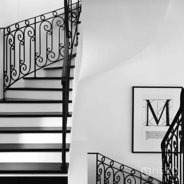 Townhouse for sale - Curved staircase with black wrought-iron balustrade against white walls in a stylish townhouse interior.