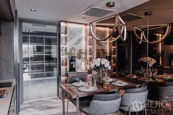 公寓 出售 - 奢华餐厅区，吊灯、镜面墙与大理石饰面，餐桌整齐摆放。