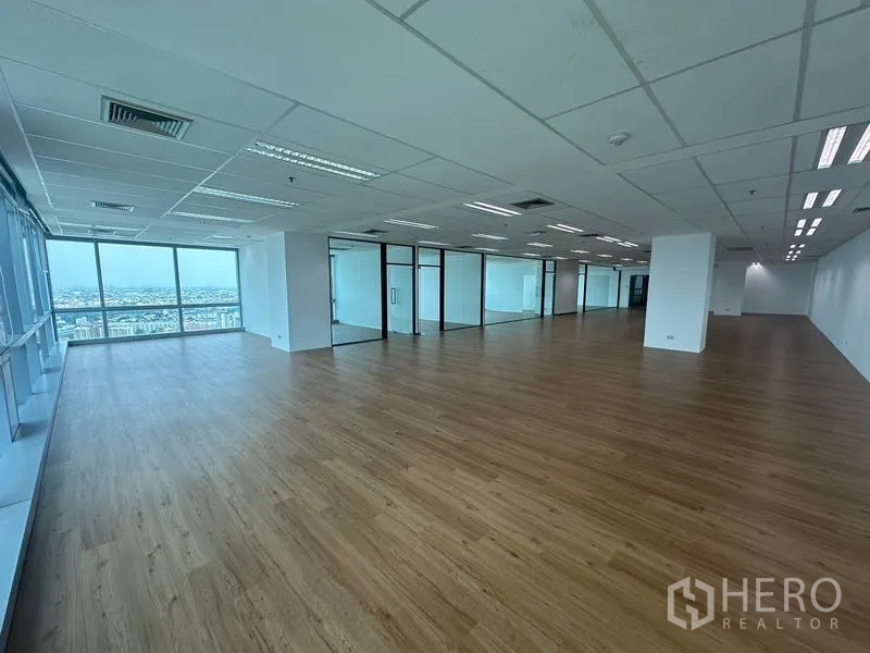 Office Space for rent - Large office layout with glass partitions, ceiling air vents and abundant natural light from wide windows.