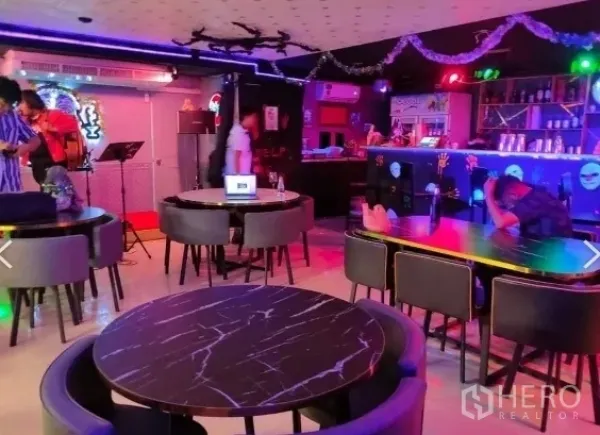 零售空间 出租在Watthana, Bangkok - 霓虹灯氛围的用餐与休闲区，配大理石圆桌和吧台。