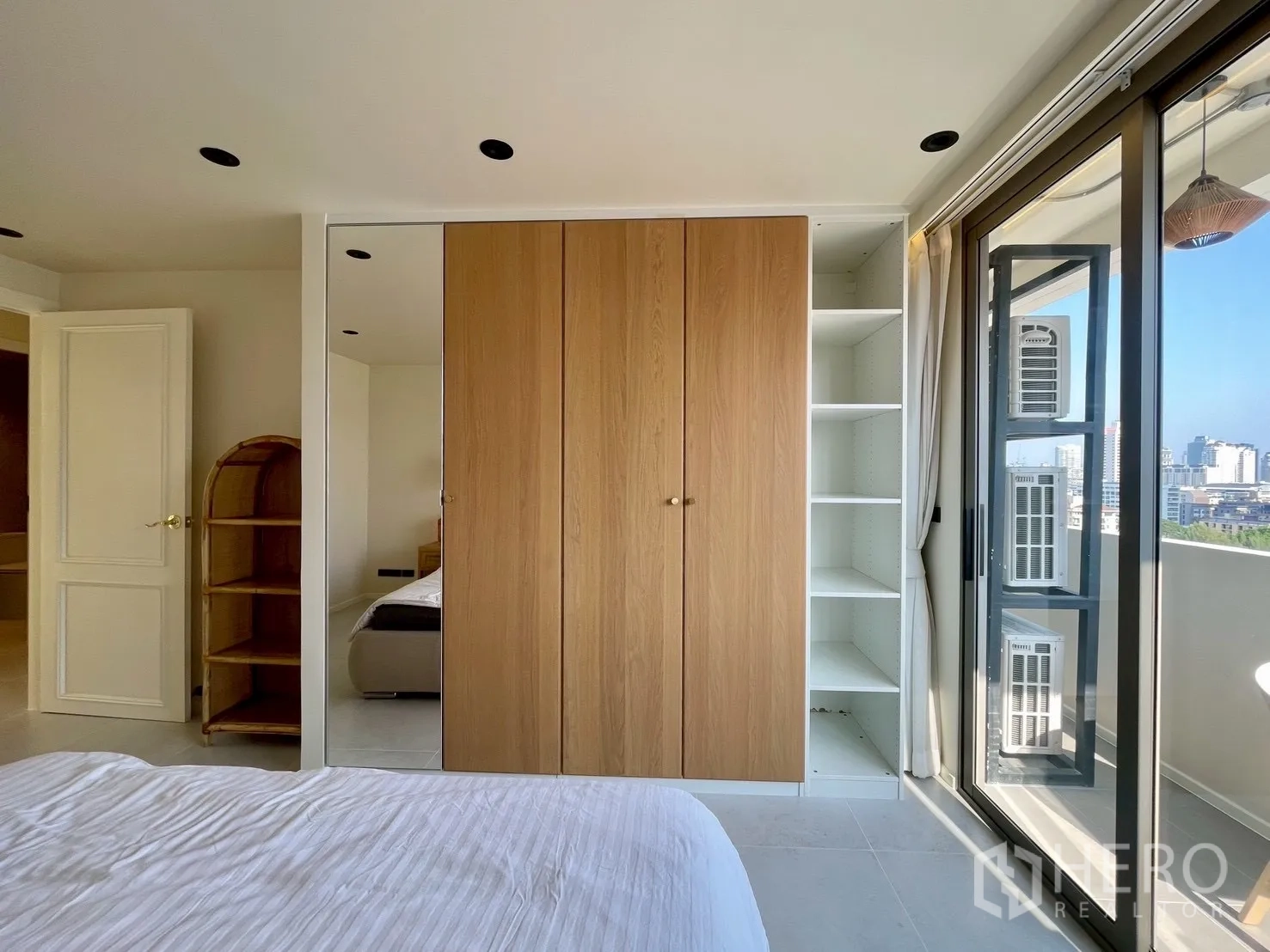 Condominium for sale in Watthana, Bangkok - Wardrobe wall with mirrored door and shelves beside balcony access.