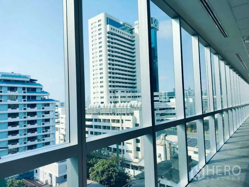 Office Space for rent in Sathon, Bangkok - Urban cityscape and neighboring towers framed by expansive glass windows.