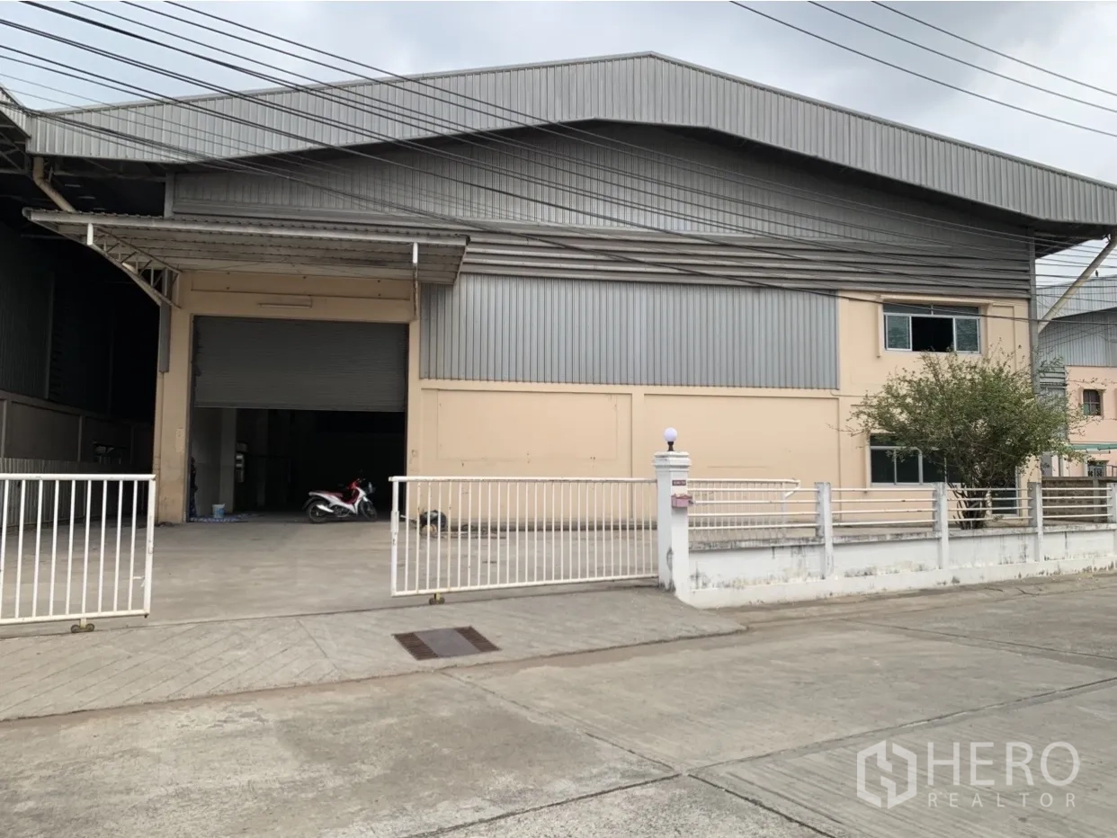 โรงงาน ให้เช่าในMueang Samut Prakan, Samut Prakan - ด้านหน้าโรงงานโครงเหล็ก ผนังเมทัลชีต พร้อมประตูรั้วและทางเข้ากว้าง