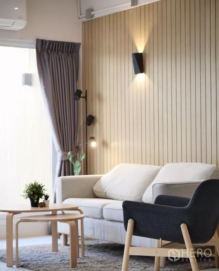 联排别墅 出租或出售在Watthana, Bangkok - 温馨沙发角，木质竖条墙与层次照明。