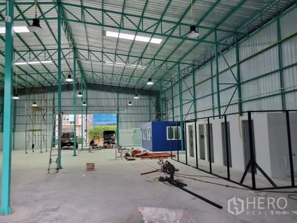 货栈 出租在Saphan Sung, Bangkok - 仓库内部挑高空间，钢结构桁架，天窗与明亮照明，并设有可做办公室的模块化房间。