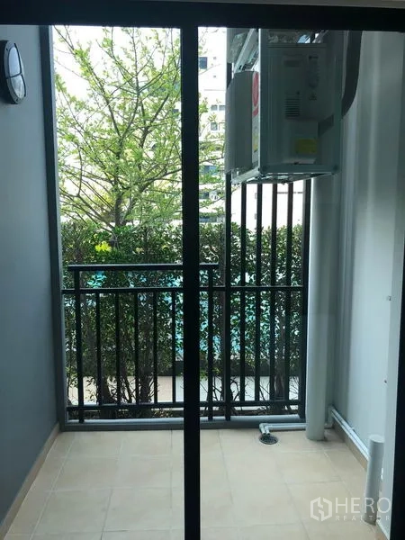 คอนโด ขายในKhlong Toei, Bangkok - ระเบียงขนาดกะทัดรัด ราวเหล็กสีดำ คอยล์แอร์ภายนอก และวิวใบไม้