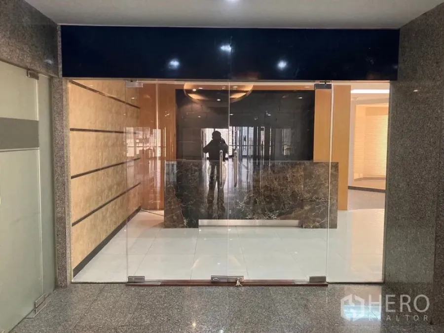 สำนักงาน ให้เช่า - ทางเข้าแบบประตูกระจกใส เปิดสู่เคาน์เตอร์ต้อนรับหินอ่อน ในอาคารสำนักงาน