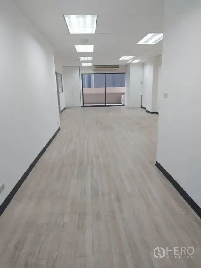 办公空间 出租在Pathum Wan, Bangkok - 采光良好的开放式办公室，木纹地板，嵌入式灯具，推拉玻璃门通向阳台。