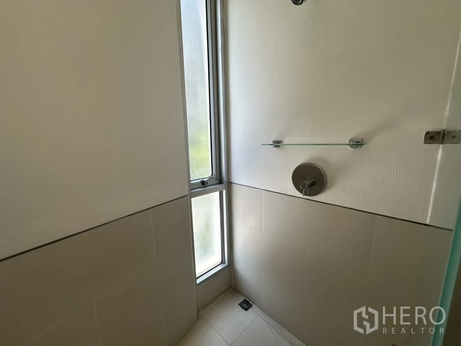 Home Office for rent in Phra Khanong, Bangkok - Shower area with a frosted vertical window and wall fixtures.
