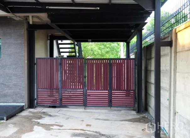 สำนักงานที่บ้าน ให้เช่าในLat Phrao, Bangkok - ทางเข้าด้านข้าง ประตูซี่สีแดงใต้หลังคา พร้อมบันไดนอกอาคาร