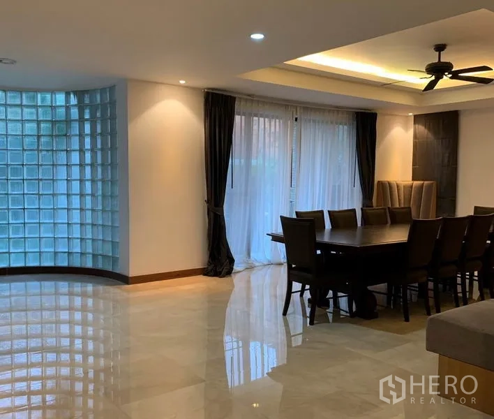 Detached House for rent in Din Daeng, Bangkok - Open-plan space with a glass-block feature wall and dining area.
