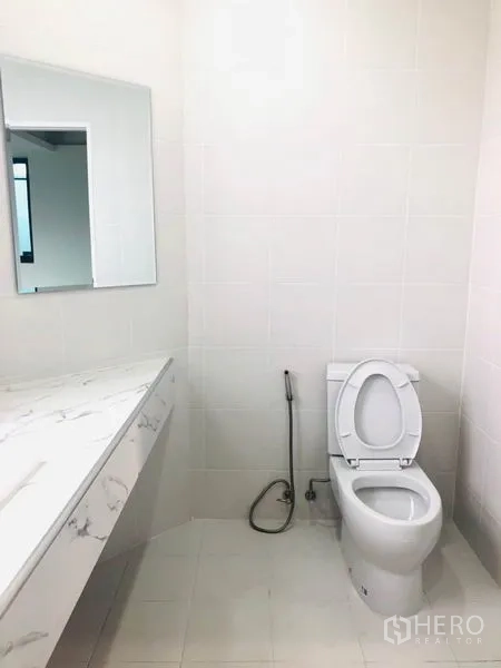 สำนักงานที่บ้าน ให้เช่าในKhlong Toei, Bangkok - ห้องน้ำโทนขาวเรียบง่าย มีโถสุขภัณฑ์ สายชำระ และเคาน์เตอร์ท็อปลายหินอ่อน