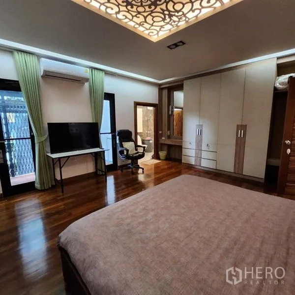 บ้าน ขายในPhra Khanong, Bangkok - ห้องนอนมีตู้เสื้อผ้าบิวท์อิน โต๊ะทำงาน ทีวี และประตูออกระเบียง พร้อมแอร์