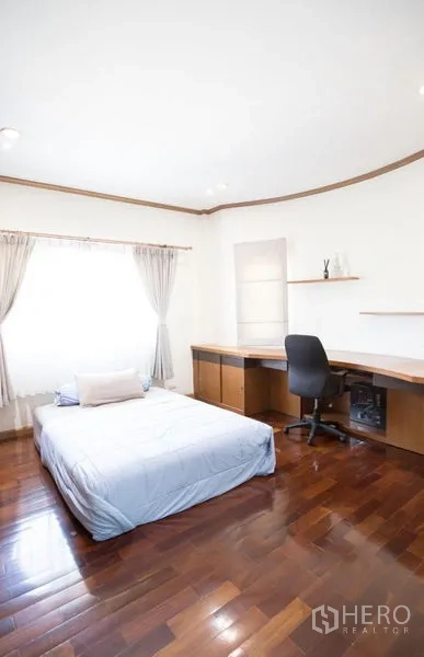 บ้าน ขายในLat Krabang, Bangkok - ห้องนอนรองพร้อมหน้าต่างบานใหญ่ โต๊ะทำงานบิวท์อินมุมห้อง และพื้นไม้