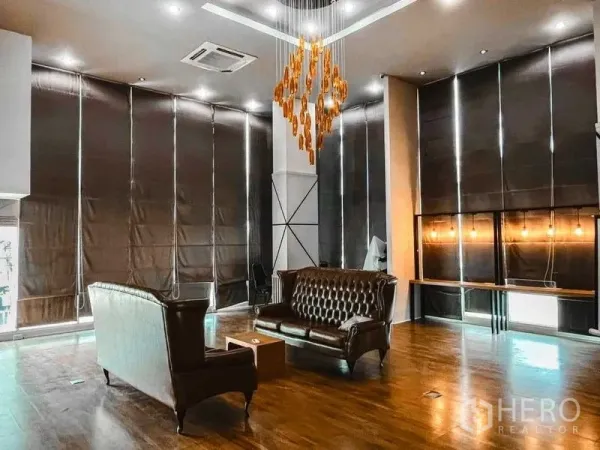 Office Space for rent in Lak Si, Bangkok - Office seating corner with tufted leather sofas, long built-in counter with warm pendant bulbs, high ceilings and large blackout blinds.