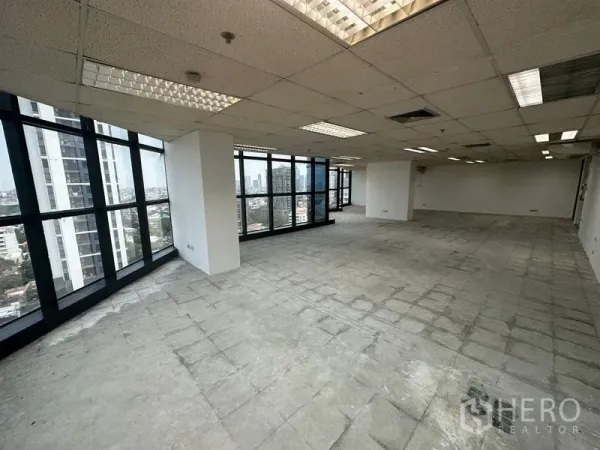 สำนักงาน ให้เช่า - พื้นที่ทำงานสว่าง เพดานกริดพร้อมไฟฟลูออเรสเซนต์ และกระจกเต็มบาน มองเห็นตึกสูง