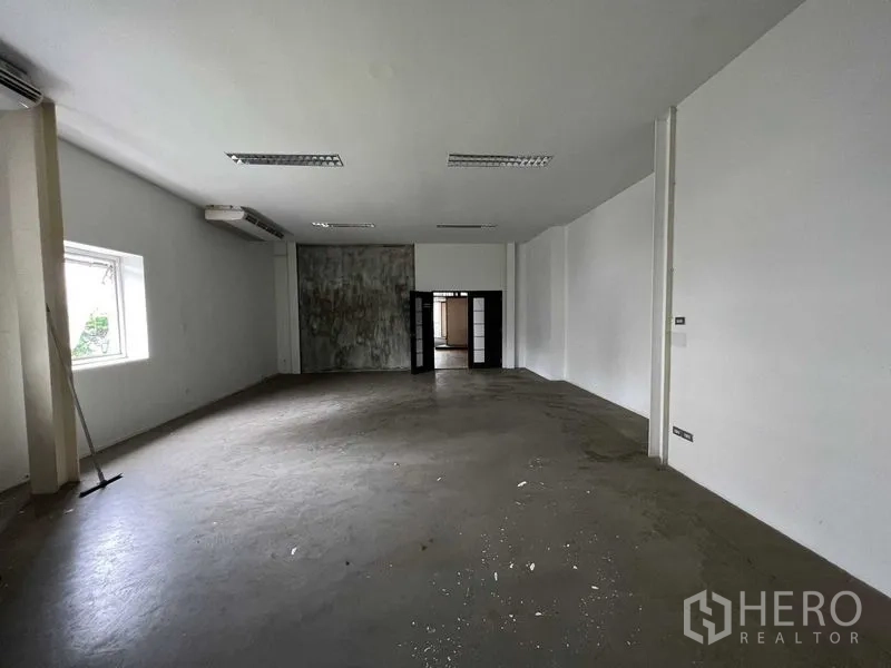 零售空间 出租 - 后勤空房，白色墙面、空调机和水泥地面