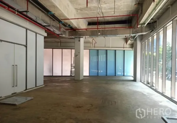 零售空间 出租在Watthana, Bangkok - 店铺另一角度：中央立柱、双开门入口与磨砂玻璃墙，自然采光充足