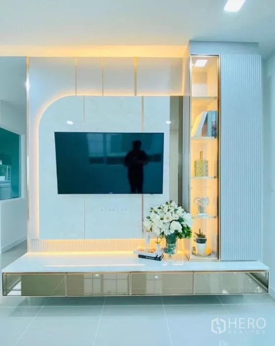 บ้าน ให้เช่าในPrawet, Bangkok - มุมห้องนั่งเล่นบิวท์อินผนังทีวี ไฟซ่อน LED อบอุ่น และตู้โชว์กระจก.
