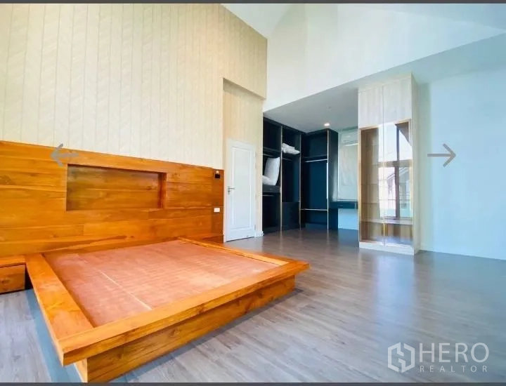 Detached House for sale in Saphan Sung, Bangkok - Master suite with platform bed and open walk-in closet cabinetry.