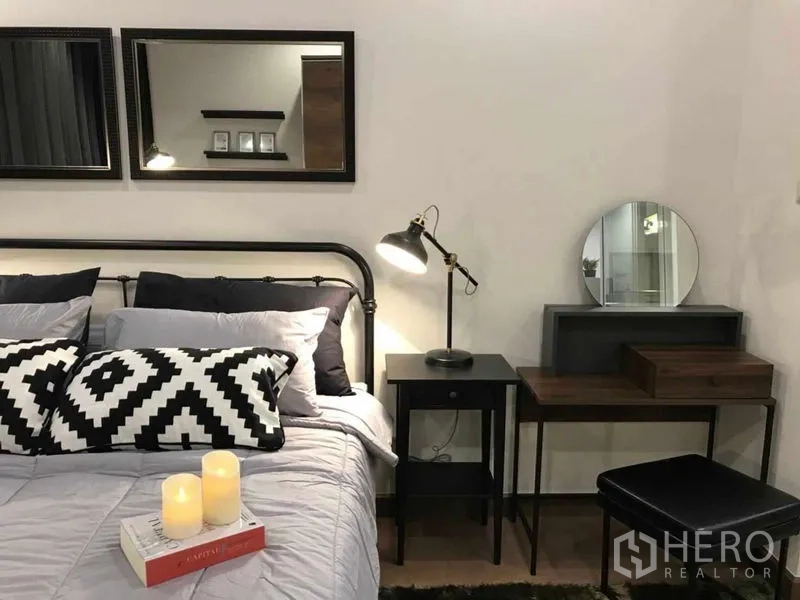 คอนโด ให้เช่าหรือขายในRatchathewi, Bangkok - ห้องนอนพร้อมชุดเครื่องนอนสบาย หมอนลายขาวดำ โคมไฟข้างเตียง กระจกติดผนัง และโต๊ะเครื่องแป้ง