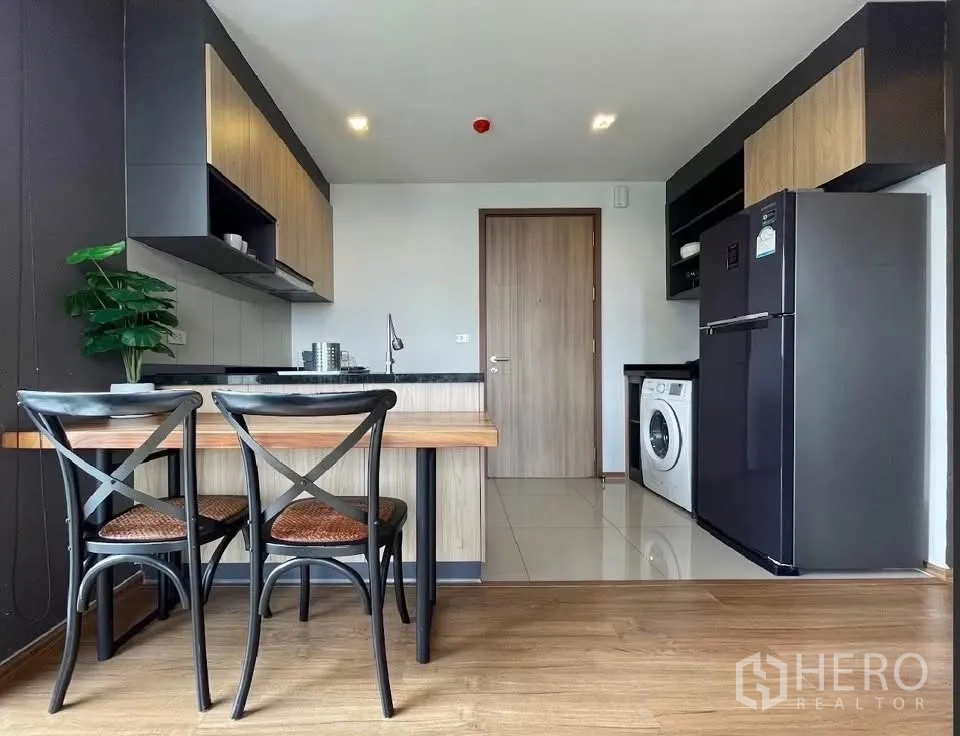คอนโด for rent in Watthana, Bangkok - มุมครัวและโต๊ะอาหารพร้อมตู้เย็นและเครื่องซักผ้าในแปลนเปิดโล่ง