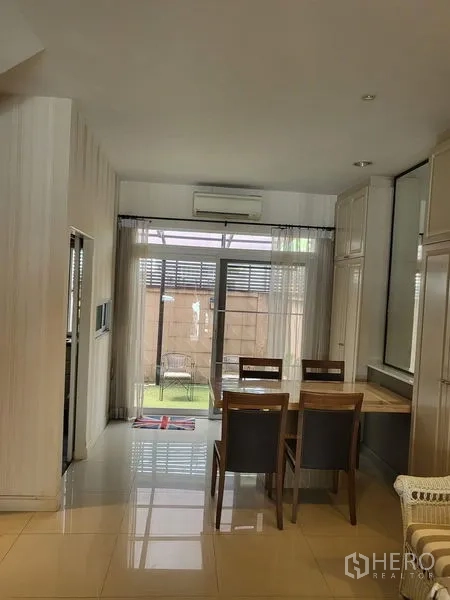 Townhouse for rent in Wang Thonglang, Bangkok - Dining area with four chairs beside sliding glass doors to the patio.