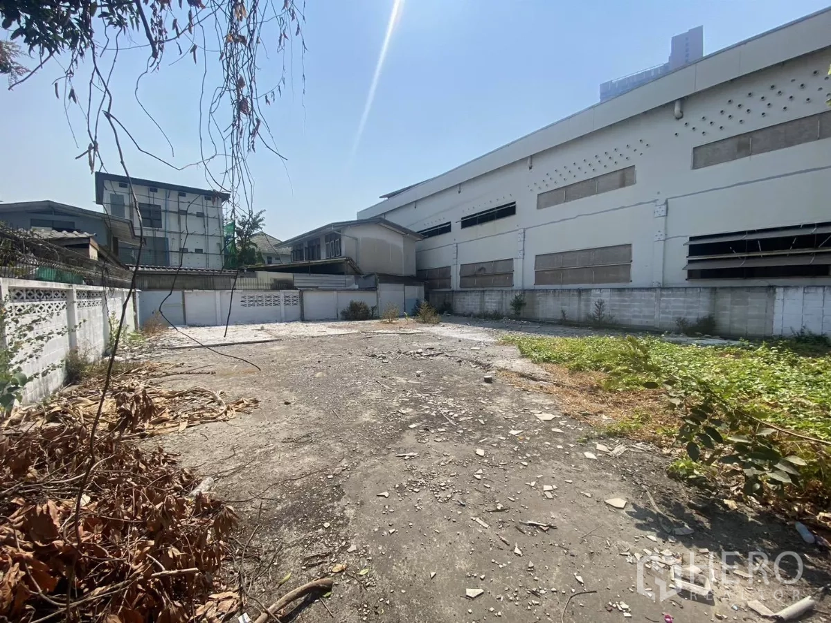 Land for rent in Khlong Toei, Bangkok - Wide view of empty inner-city land with partial greenery and high perimeter walls in Bangkok.