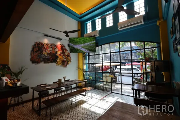 店屋 出租或出售在Khlong Toei, Bangkok - 挑高餐厅空间，钢框落地玻璃门、墙面壁画与花纹地砖