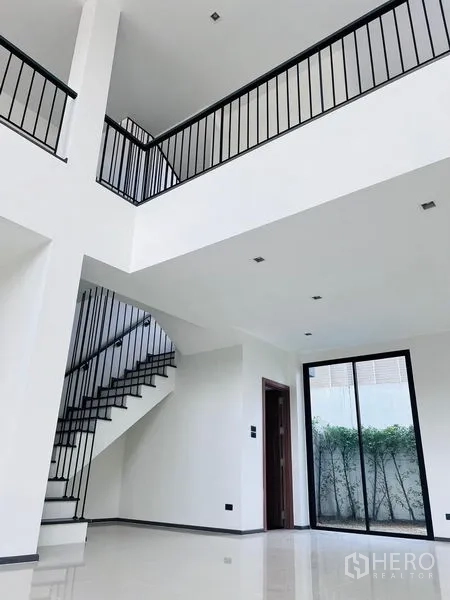 สำนักงานที่บ้าน ขายในBang Khen, Bangkok - มุมมองโถงกลาง เห็นทางเดินชั้นลอย บันได และประตูกระจกสไลด์ออกสวนเล็ก