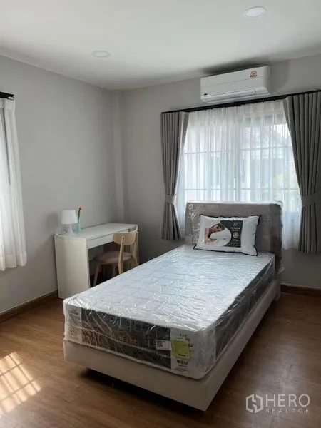 Detached House for rent in Bang Phli, Samut Prakan - Light-filled bedroom with single bed, work desk and wall-mounted air conditioning.