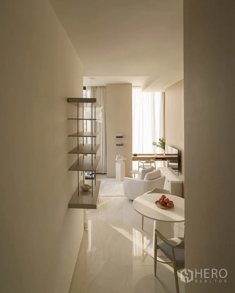 Condominium for rent in Bang Rak, Bangkok - Hallway leading to bright living area with shelving and a round dining table.