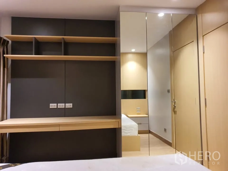 คอนโด for rent in Watthana, Bangkok - มุมทำงานในห้องนอนพร้อมโต๊ะบิลต์อิน ชั้นวาง และตู้เสื้อผ้าบานกระจก
