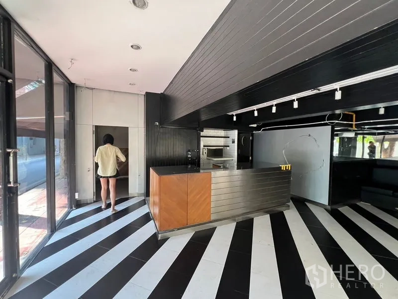 零售空间 出租在Bang Rak, Bangkok - 玻璃围合店铺，条纹地面与轨道照明。