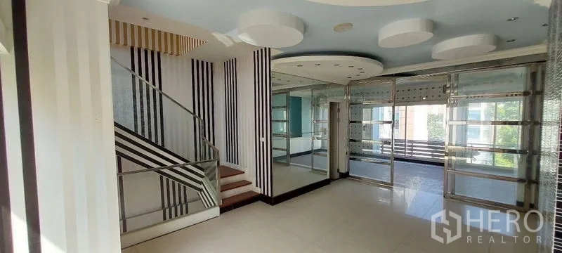 Home Office for sale in Wang Thonglang, Bangkok - Bright level with balcony access, striped columns and ceiling lights.