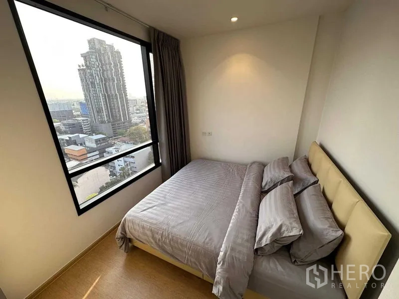 公寓 出售 - 次卧大窗景观，双人床与灰色床品。