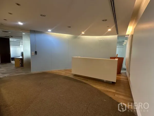 สำนักงาน ให้เช่าในWatthana, Bangkok - โถงต้อนรับปูพรมโค้ง พื้นไม้ และเคาน์เตอร์ต้อนรับสีขาวในออฟฟิศทันสมัย