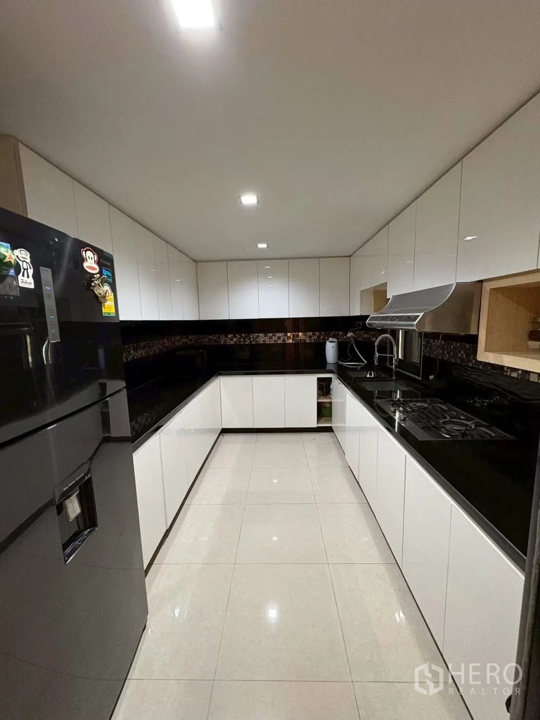 联排别墅 for rent in Pathum Wan, Bangkok - U型现代厨房，白色柜体与亮面瓷砖地面。