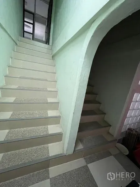 Shophouse for sale in Sathon, Bangkok - Two internal staircases with pastel walls connecting to the upper floors.