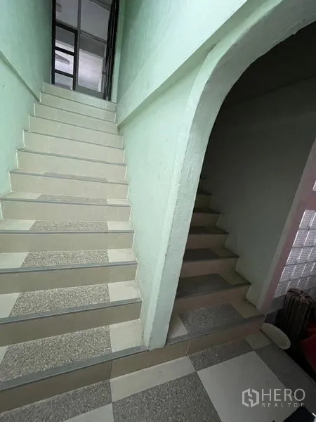 Shophouse for sale in Sathon, Bangkok - Two internal staircases with pastel walls connecting to the upper floors.