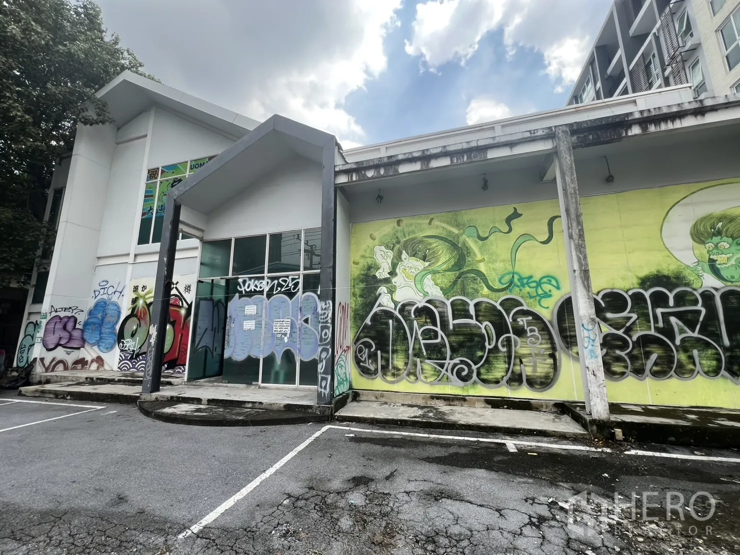 พื้นที่ขายปลีก ให้เช่าในWatthana, Bangkok - ผนังด้านข้างอาคารมีกลางฟิตี้สีสันและช่องจอดรถ