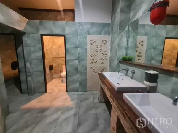 พื้นที่ขายปลีก ให้เช่าในWatthana, Bangkok - ห้องน้ำปูกระเบื้องสีเขียว มีอ่างล้างหน้าทรงเหลี่ยมคู่ กระจกบานยาว และห้องส้วมสองห้อง