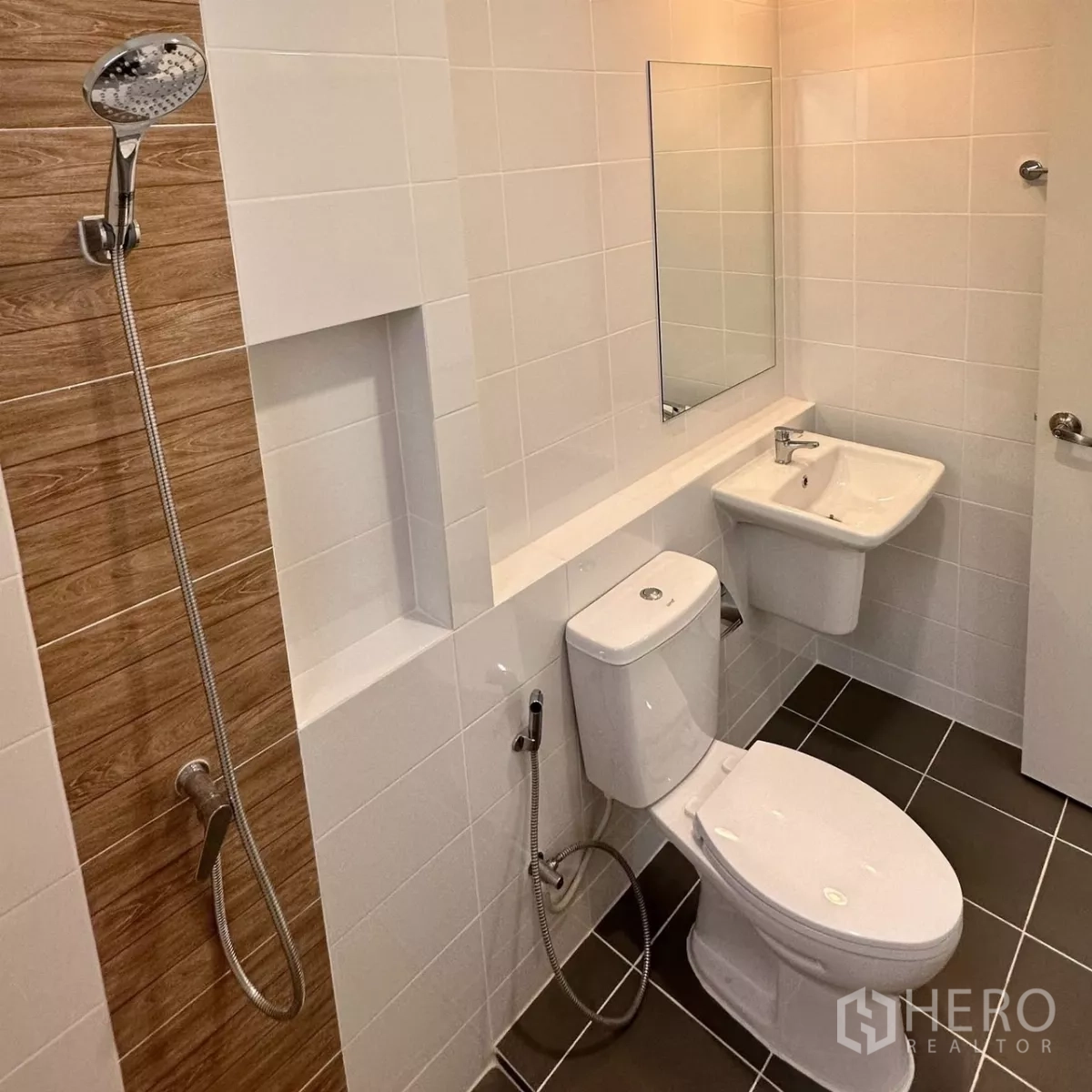 Townhouse for rent in Bang Phli, Samut Prakan - Clean bathroom with shower area, toilet, basin and water heater on white tiles.