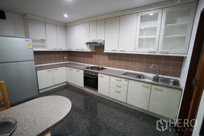 อพาร์ทเมนท์ ให้เช่าในWatthana, Bangkok - ครัวปิดรูปตัวแอล ตู้สีขาว เตาแก๊ส และตู้เย็นขนาดใหญ่