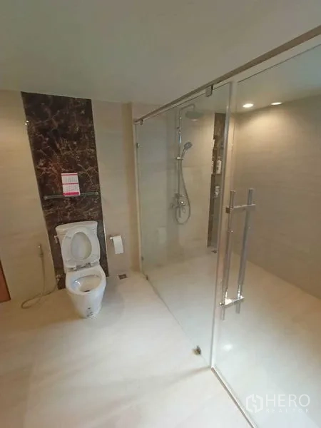 Home Office for rent in Watthana, Bangkok - Modern bathroom with glass shower enclosure and toilet.