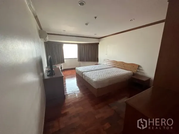 คอนโด ให้เช่าในWatthana, Bangkok - ห้องนอนขนาดใหญ่ พื้นไม้ เตียงคู่ พร้อมหน้าต่างและโต๊ะข้างเตียง