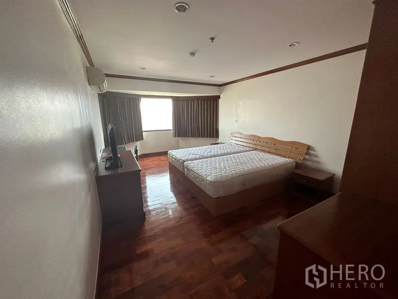 คอนโด ให้เช่าในWatthana, Bangkok - ห้องนอนขนาดใหญ่ พื้นไม้ เตียงคู่ พร้อมหน้าต่างและโต๊ะข้างเตียง