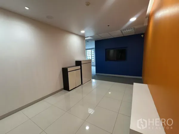 办公空间 出租在Watthana, Bangkok - 明亮的接待走廊，橙色与蓝色墙面，内置柜体。